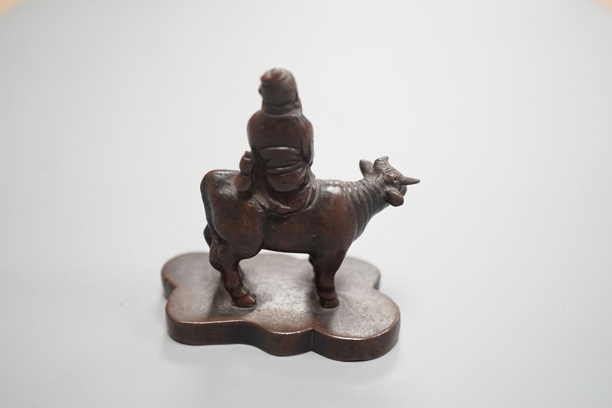 A small Chinese bronze seal of an immortal riding a bull and a Tibetan prayer case 9cm